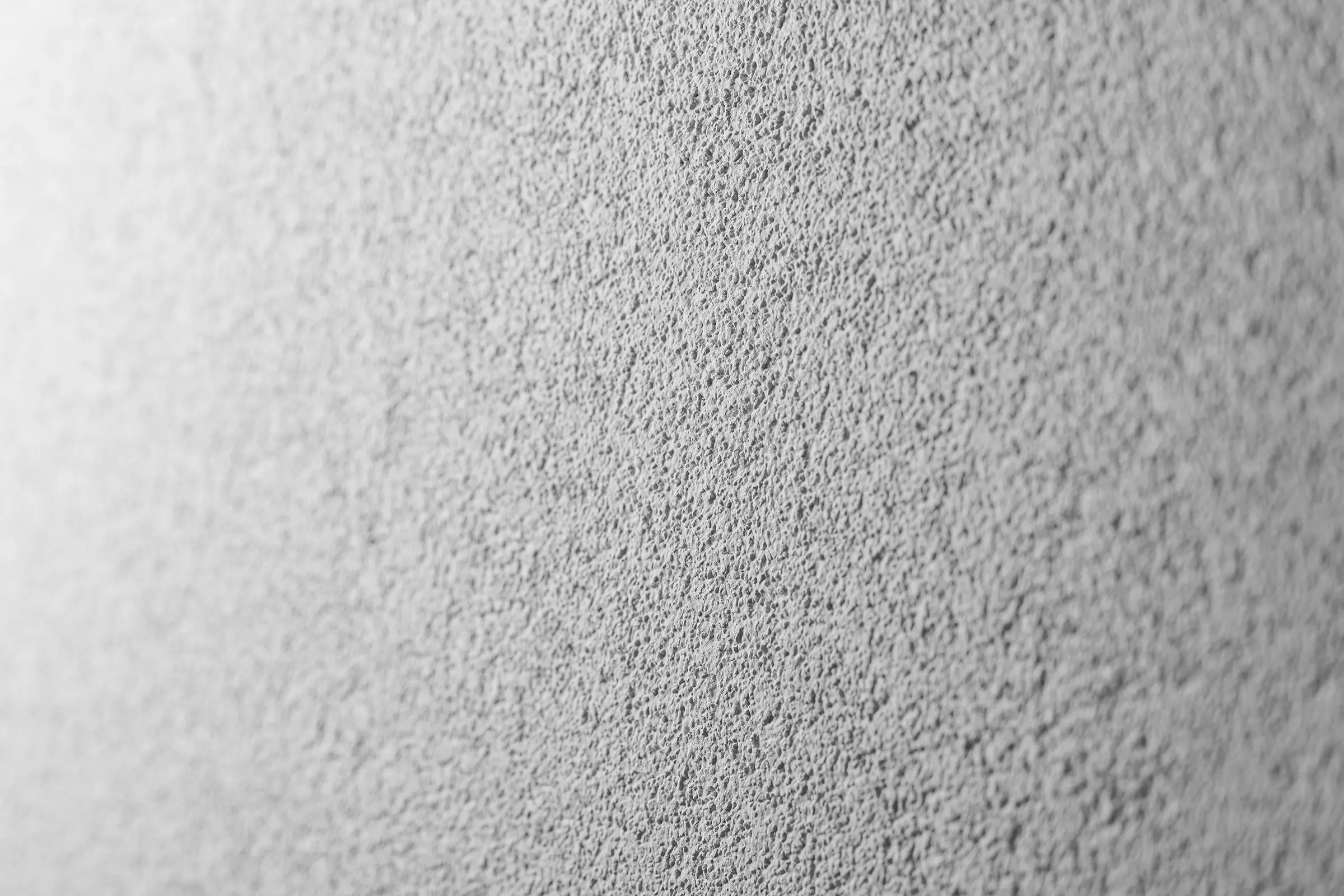 Tynk drapany, tynk StoSignature, faktura Rough, szara powierzchnia tynkowana.