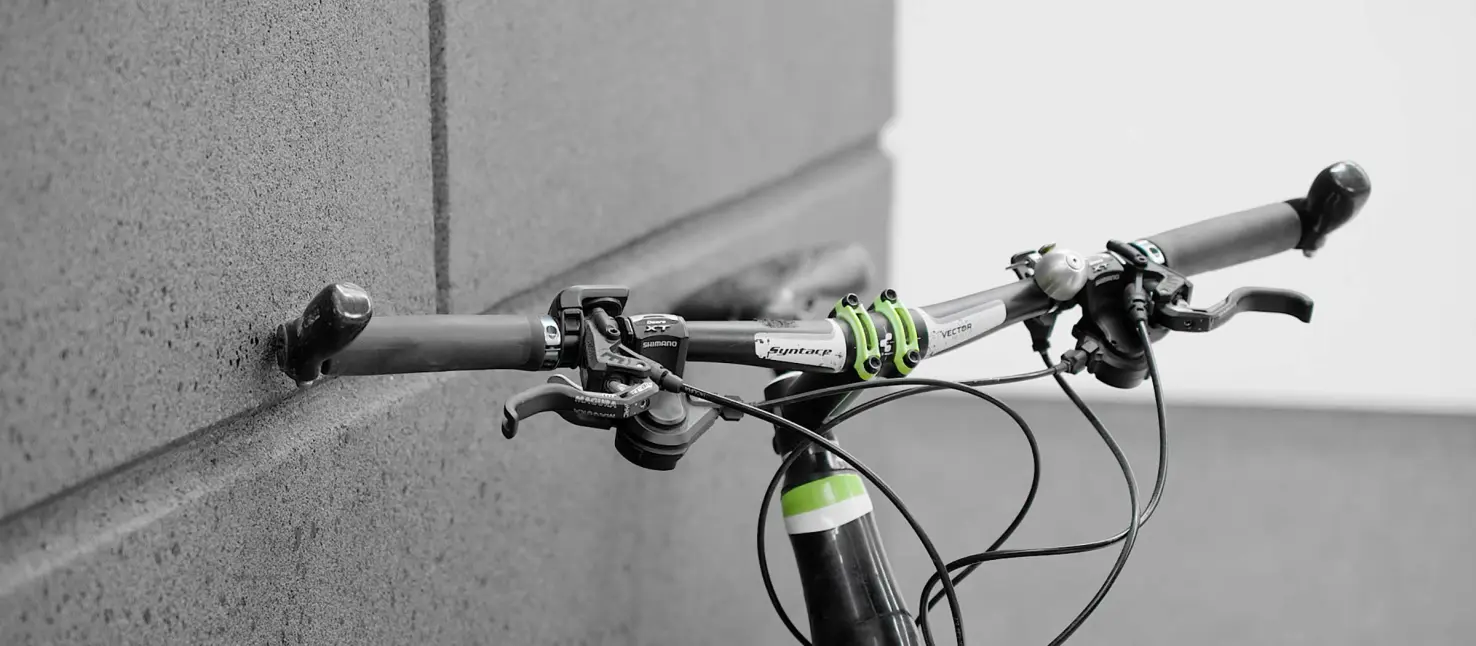 Trwały tynk kamyczkowy: kierownica roweru oparta o antracytową elewację domu