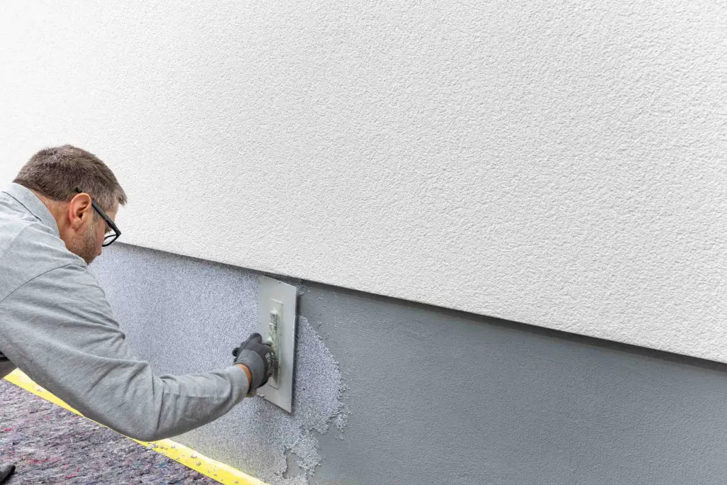 Tynk StoSuperlit® chroni cokół przed warunkami atmosferycznymi. Aplikacja za pomocą pacy.