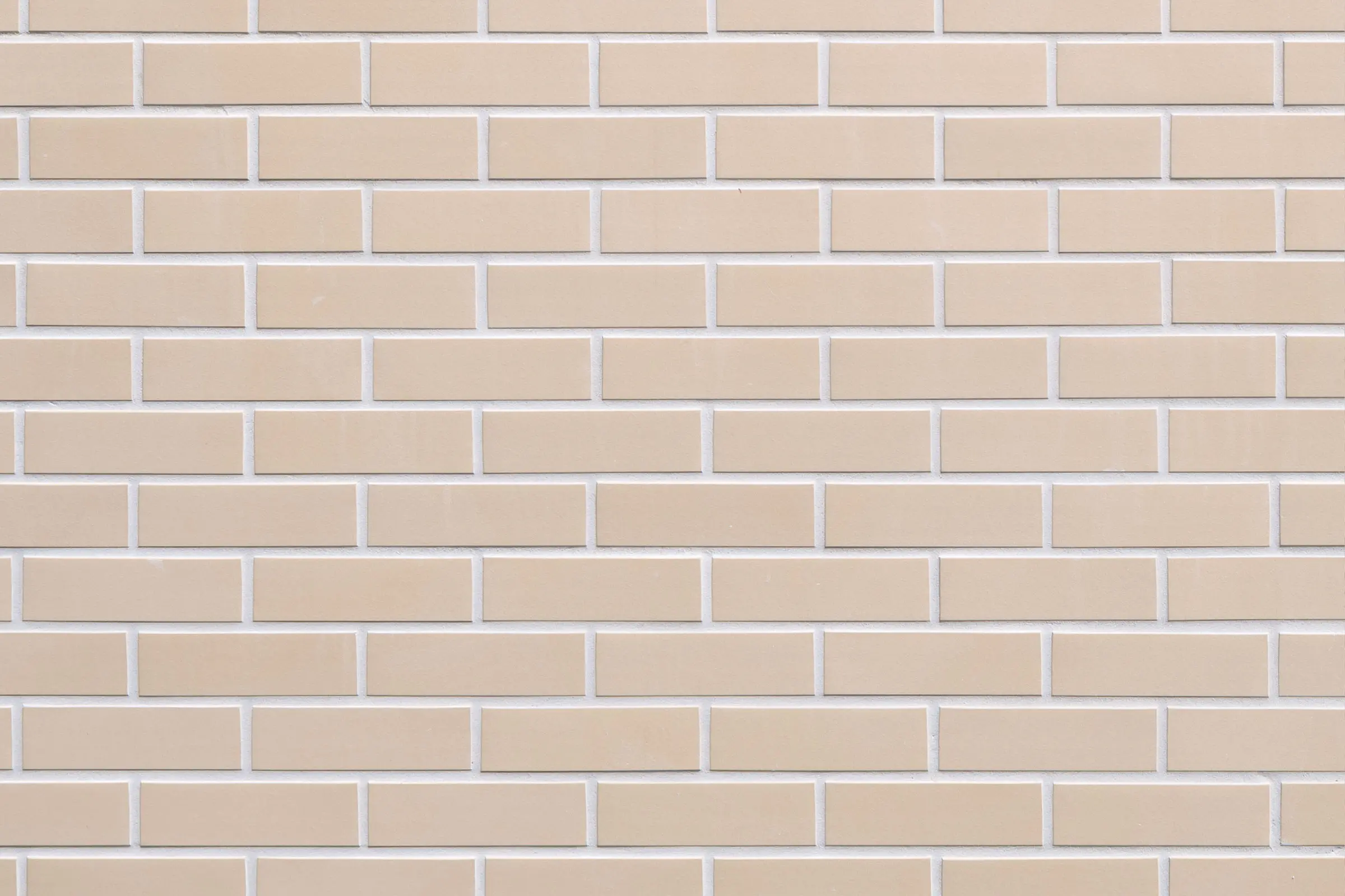 Zbliżenie cyfrowe elewacji StoBrick Klinker z jasnobeżowej cegły.